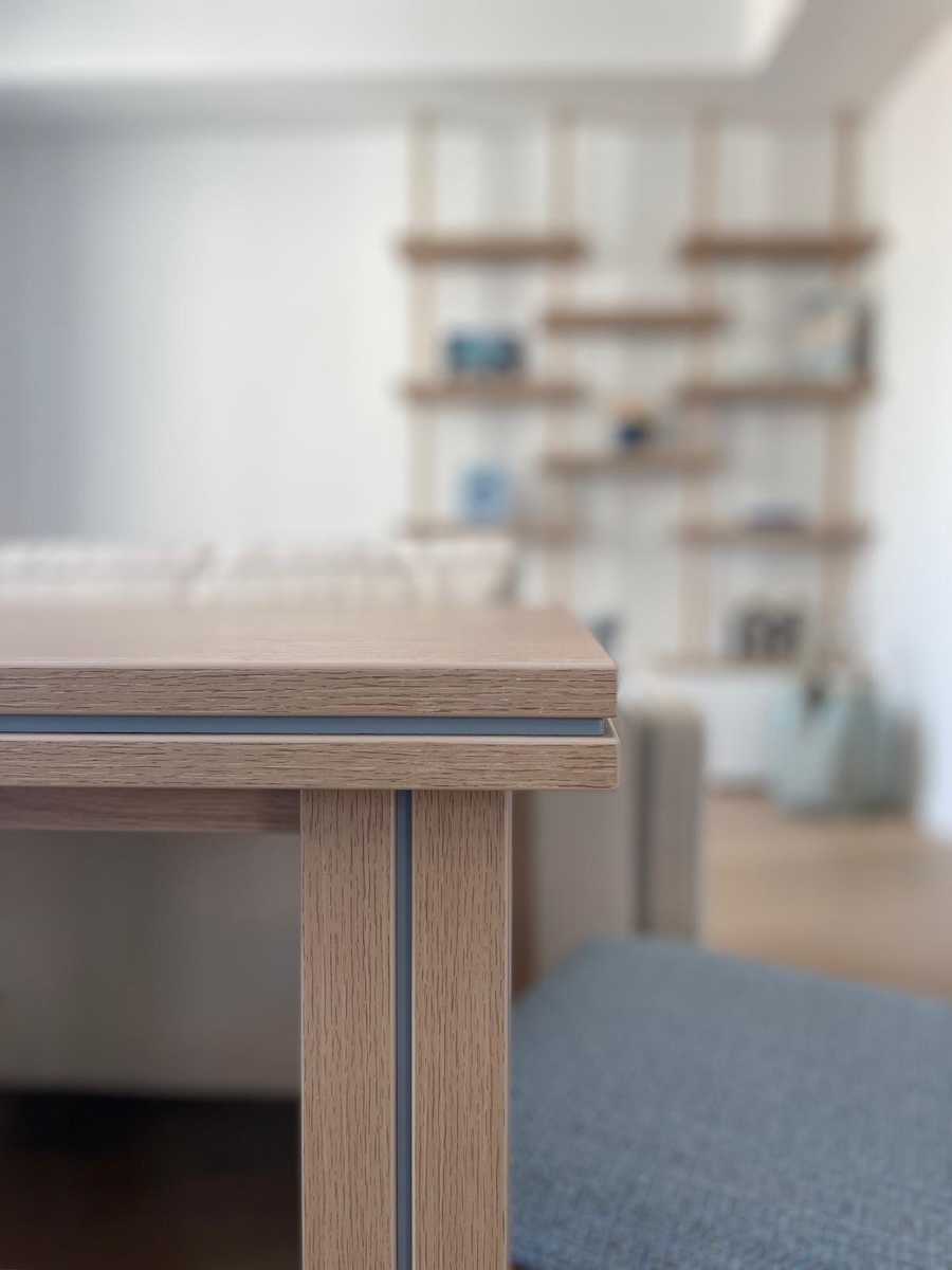 Détail de la table de salle à manger du projet Radieuse à Monaco avec lignes graphiques, finition bois et perspective sur le salon signé Intérieurs à Croquer