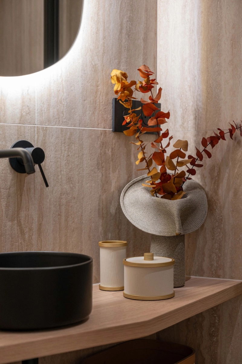 Détail de salle de bain avec vasque noire, plan en bois et revêtement minéral – Projet L’Azur par Intérieurs à Croquer