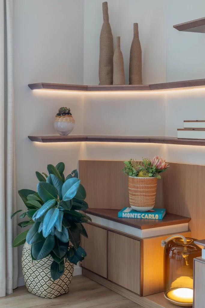 Détail salon avec rangements sur mesure, étagères lumineuses et décoration végétale – Projet L’Azur par Intérieurs à Croquer