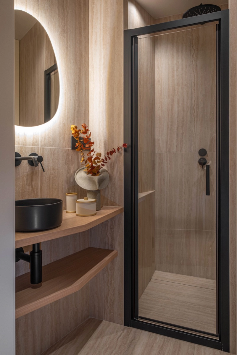 Salle de bain contemporaine avec douche vitrée, vasque noire et mobilier en bois – Projet L’Azur par Intérieurs à Croquer