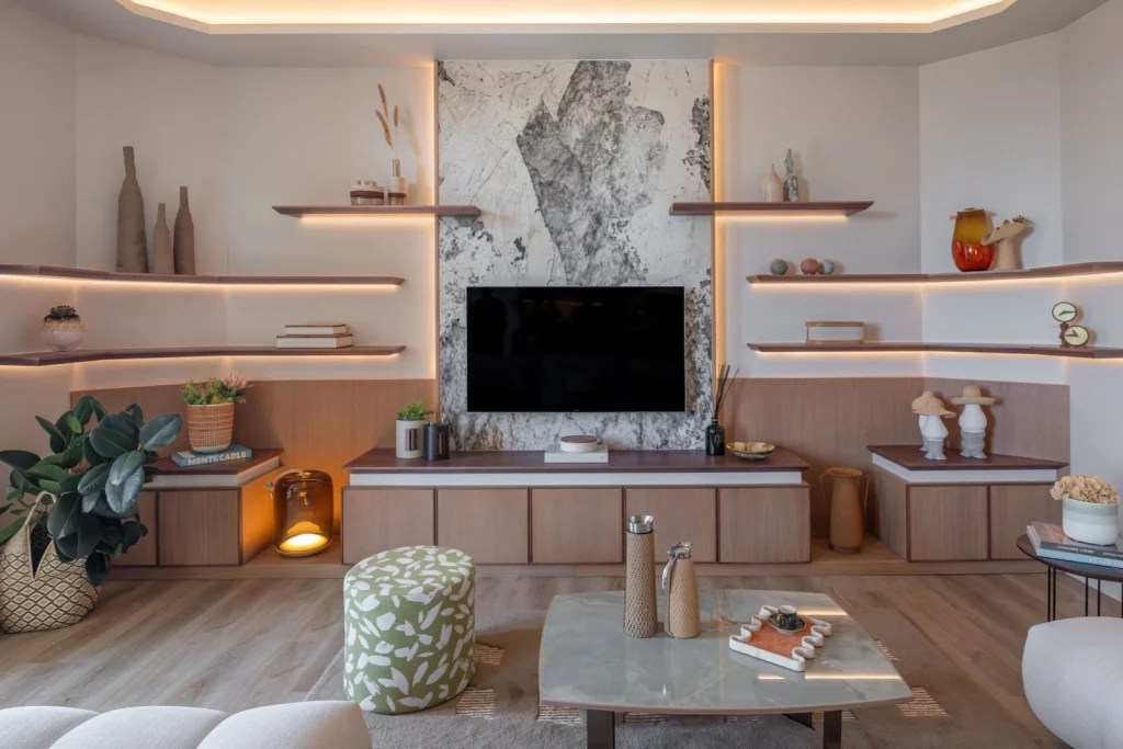 Salon contemporain avec meuble TV sur mesure, étagères rétroéclairées et mur en marbre – Projet L’Azur par Intérieurs à Croquer