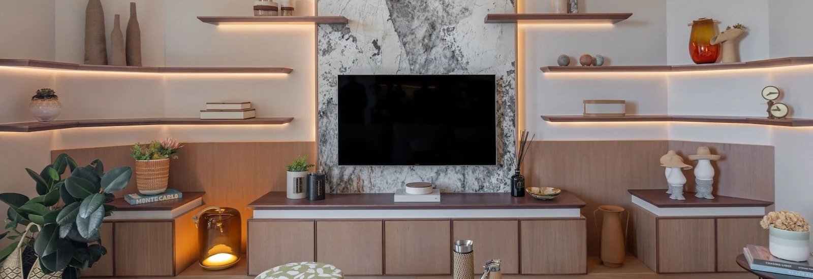 Projet L’Azur Monaco par Intérieurs à Croquer : salon contemporain avec mobilier sur mesure, étagères lumineuses et habillage mural en pierre naturelle