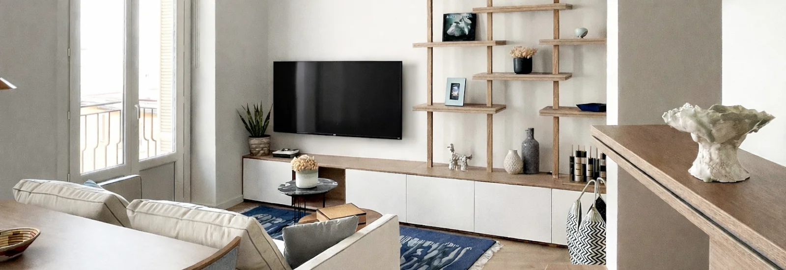 Projet Radieuse Monaco par Intérieurs à Croquer : salon contemporain avec mobilier sur mesure, bibliothèque graphique en bois et lignes épurées